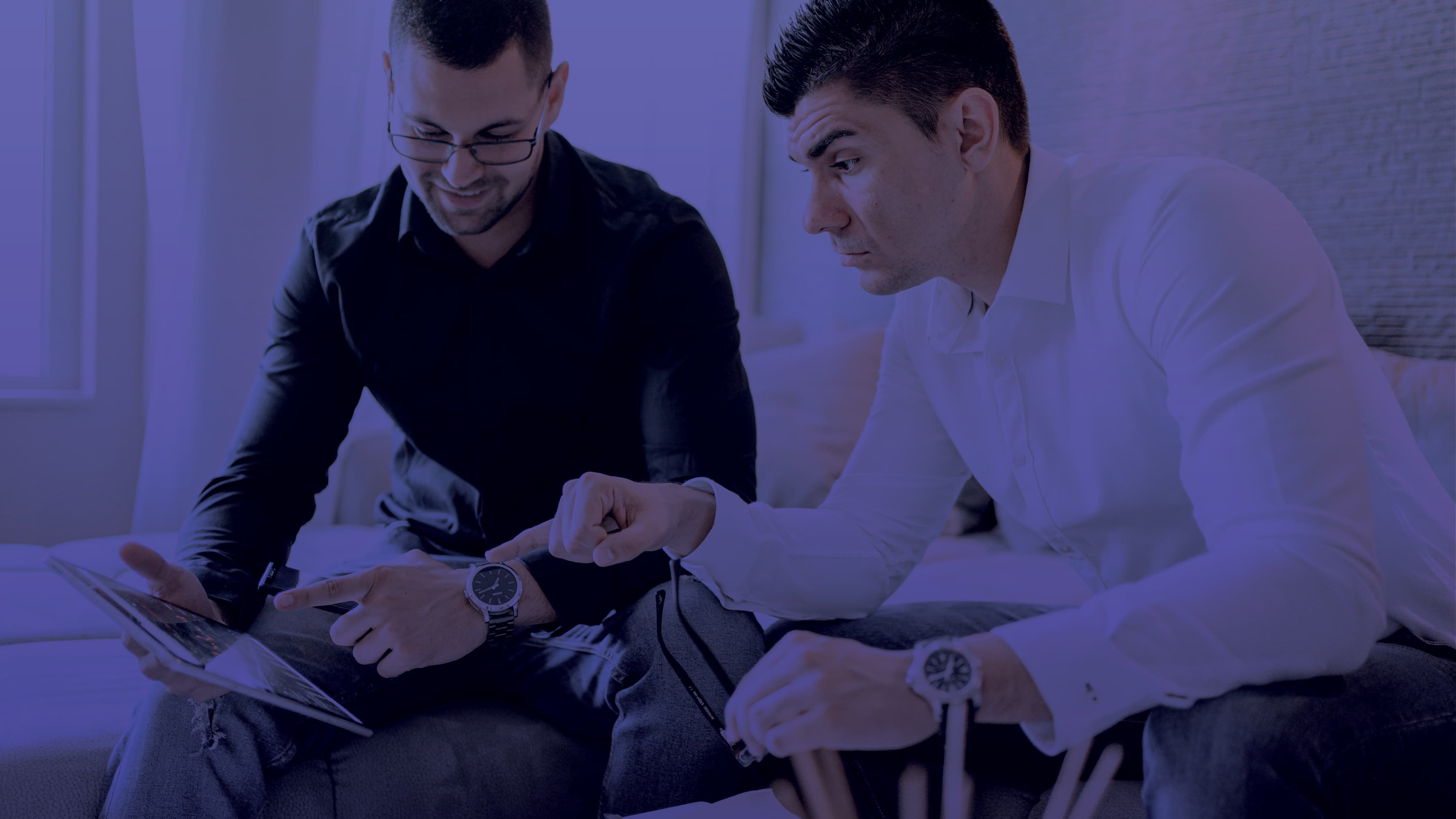 Two meeting sitting looking at a computer