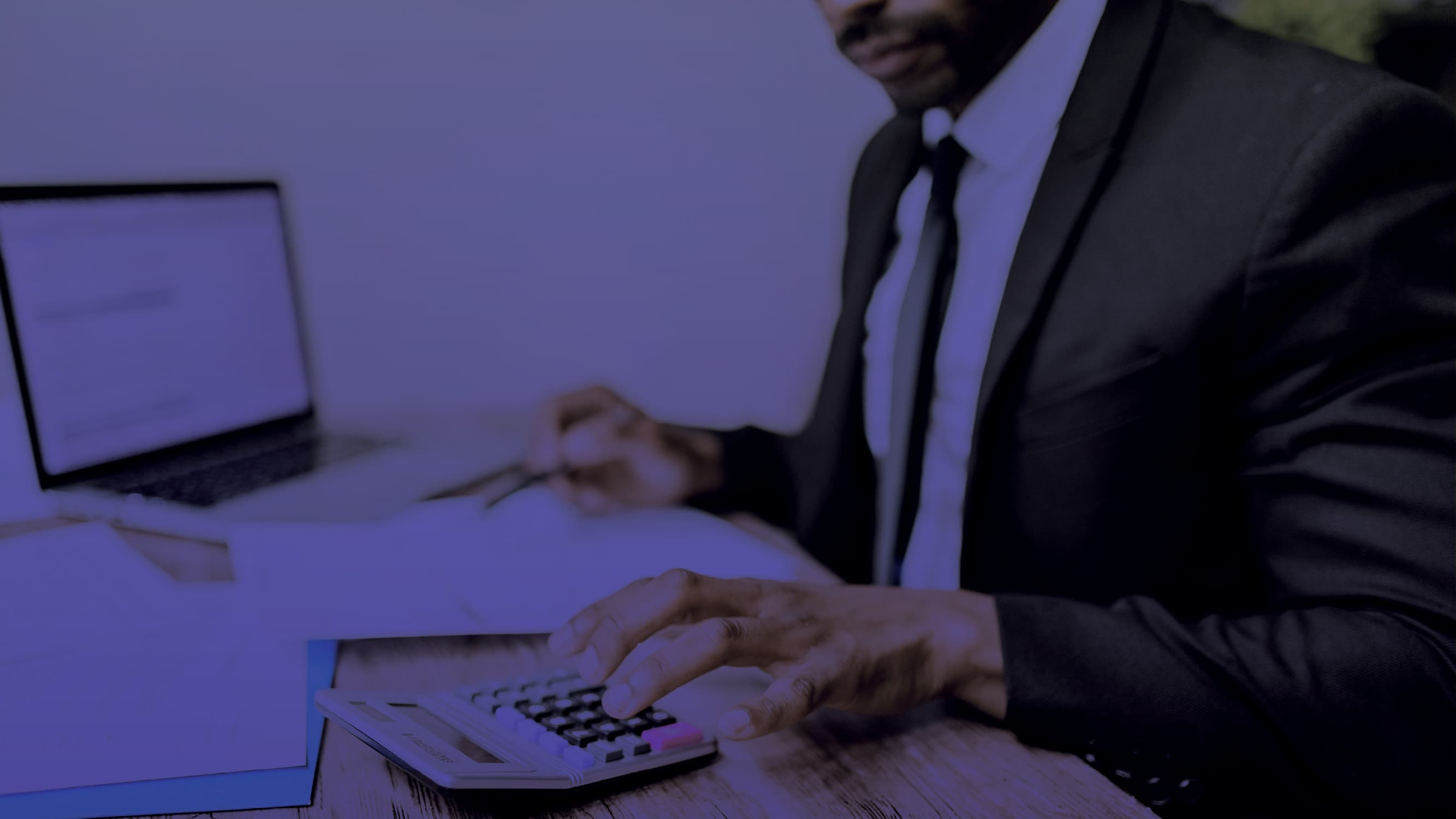 Businessman using a calculator at his desk